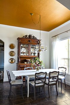 a dining room table with chairs and a china cabinet