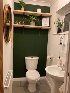 a small bathroom with green walls and white fixtures