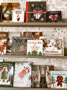 several christmas books are on the shelves in a room with white wallpaper and patterned walls