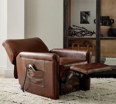 a brown recliner chair sitting on top of a white rug