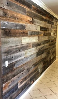 a wall made out of wooden planks in a room with tile flooring and white walls