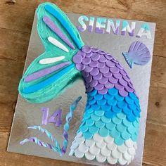 a cake made to look like a mermaid fish with purple and blue scales on it