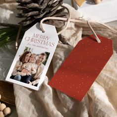 a christmas ornament with a photo on it next to some pine cones and other holiday decorations