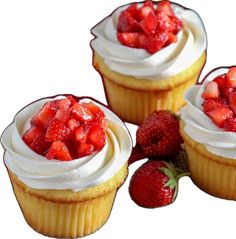 three cupcakes with white frosting and strawberries on top