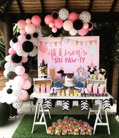 an outdoor birthday party with balloons and desserts