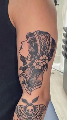 a woman's arm with a tattoo on it and a skull in the middle