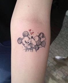 a tattoo on the arm of a person with mickey and minnie mouses head tattoos