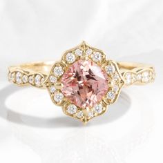 an engagement ring with a pink diamond in the center and white diamonds on the sides