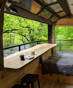 a bed sitting in the middle of a room next to a wooden table and window