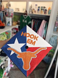 a graduation cap with the word hook em on it and a texas flag design