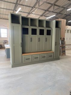 an empty storage room with several cabinets and drawers in it, all painted olive green