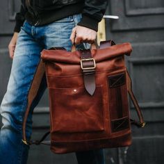 When vintage meets modern. A combination of expert craftsmanship, vintage elements and functionality gives this backpack a traditional and contemporary style. Made with quality cowhide leather that is both supple and durable, it comes with a roll-top design and a roomy, denim-lined interior to provide versatile and ample storage. With added vintage upcycled elements, it is a backpack that meets the urbanite's desire for the unique and timeless.  Build to last. Free personalization available. PRO Modern Brown Backpack For Everyday Carry, Rugged Backpack For Everyday Use, Leather Backpack With Leather Patch For Everyday Carry, Modern Brown Leather Backpack For Outdoor, Leather Backpack Men, Laptop Purse, Men Christmas Gift, Vintage Meets Modern, Roll Top Backpack