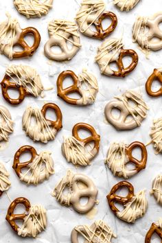 many pretzels are covered in white icing and drizzled with frosting