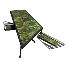 a table with green tiles on it and two folding trays underneath the table top