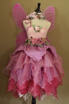 a pink and purple dress on a mannequin with flowers in the bottom part