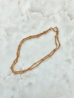 This is a beautiful double strand bracelet. It is made of 14/20 gold-fill and had small round gold beads attached to the chain all the way around. This bracelet has two chains attached to the same clasp, so it is an all in one layering bracelet. Length: 6.75 inches. If you need a different size please leave me a note at checkout. Matching Necklace: https://www.etsy.com/listing/239145000/double-strand-gold-beaded-chain-necklace?ref=shop_home_active_16 Gold Multi-strand Beaded Bracelets For Layering, Gold Double Strand Beaded Bracelet Gift, Gold Double Strand Beaded Bracelet For Gift, Gold Beaded Bracelets With Ball Chain For Everyday, Gold Adjustable Ball Chain Bracelet, Adjustable Double Chain Gold Bracelet, Gold Bracelets With Double Chain And Adjustable Fit, Gold Double Strand Bracelets With Delicate Chain, Everyday Gold Beaded Bracelets With Ball Chain