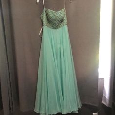 This Is A Strapless Sherri Hill Pageant Dress That Is A Size 00. It Has The Bra Cups Sewn In. It Is A Mint Green Color With Gorgeous Crisscross Rhinestones Across The Bodice. It Was Worn Once And Does Have A Few Stains On The Outside Layer Of Tulle. These Stains May Come Out With Hand Washing The Few Areas. It Is Gorgeous And Still Has Plenty Of Pageant Life In It. Green Cocktail Dress With Sweetheart Neckline, Green Cocktail Evening Dress With Sweetheart Neckline, Green Prom Dress With Sheer Bodice, Green Pleated Bodice Evening Dress, Green Floor-length Dresses With Lined Bodice, Green A-line Strapless Evening Dress, Green Evening Dress With Sweetheart Neckline And Pleated Bodice, Green Evening Gown With Lined Bodice, Green Embellished Dress With Fitted Bodice