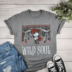 Unleash your inner free spirit with our Wild Soul Cow Skull With Red Roses Graphic T-shirt! 🌹🐮 This striking tee, featuring a bold cow skull and vibrant red roses, is perfect for anyone looking to make a statement. Made from super soft, comfortable fabric, it's ideal for everyday wear or showing off your wild side. Grab yours now at Envy Stylz Boutique! #WildSoul #GraphicTee #FreeSpirit #BoldFashion #UniqueStyle Texas Shirts Women, Bull Graphic, Texas Shirt, Country Music Shirt, Texas Shirts, Cowboy Shirt, Country Music Shirts, Cowboys Shirt, Skull Shirts