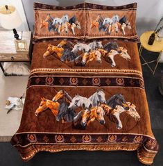 a bed with horses on it in a room next to a table and lamp,