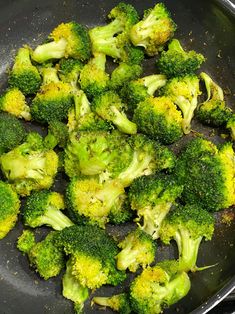 broccoli is being cooked in a wok on the stove top with some seasoning