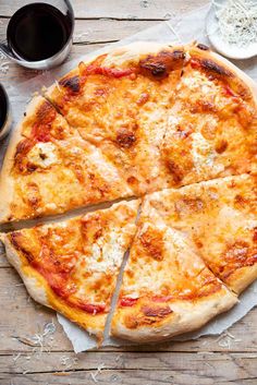 a pizza cut into four slices on top of a wooden table