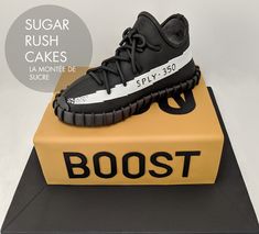 a cake made to look like a pair of shoes on top of a box with the word boost printed on it