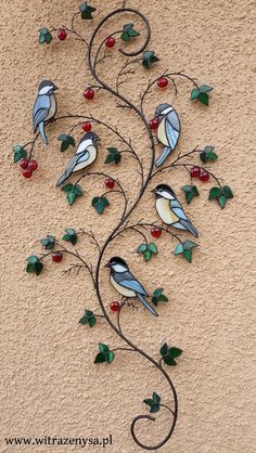 a metal wall hanging with birds and berries on it