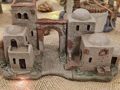 a clay model of an old building on a table with other items in the background