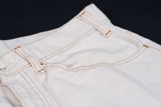 STYLE: 519 2653. SIZE: label says 33/32, actually fits W33/L28 (shortened hems). MATERIAL: 100% cotton. COLOR: cream white. FEATURES: these vintage men's Levi's 5 pocket worker pants are made of cream white cotton canvas and feature brown stretching, brass Talon zipper fastening and orange tab on back pocket suggesting these jeans are from the 70's era. First worn decades ago as a workwear garment for men who spent their days in the fields or mines, now workwear pants became adopted by just abou Vintage Cotton Jeans With Welt Pockets, Retro Cotton Pants With Belt Loops, Cotton Bottoms With Patch Pockets And Standard Cut Leg, Cotton Bottoms With Patch Pockets, White Cotton Retro Bottoms, Vintage Cotton Bottoms With Welt Pockets, Retro Cotton Pants With Welt Pockets, Retro Cotton Pants With Patch Pockets, Retro Cotton Bottoms With Welt Pockets