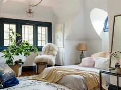 a bed room with a neatly made bed and a large mirror on the wall above it