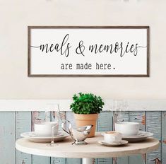 a table with plates and cups on it in front of a sign that says meal & memories are made here