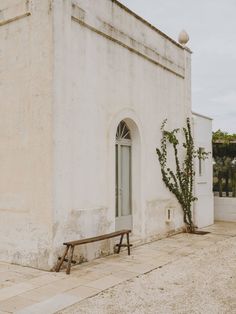 a white building with a wooden bench in front of it