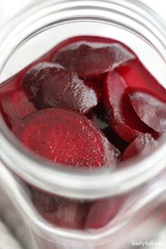 a jar filled with beets sitting on top of a table