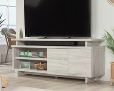 a flat screen tv sitting on top of a wooden entertainment center in a living room