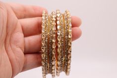 Elevate your style with a set of 4 luxurious Indian gold bangles. You can wear these to complement any outfit, whether it's to a party, wedding, or a special occasion.   Wear 4 bangles on one hand or wear 2 on each hand to add that extra wow factor.  Each bangle measures 0.25 inches. Free and fast shipping from the U.S.A! Adorn your wrists with the shimmering allure of Indian craftsmanship; these are not glass so will not break or hurt while sliding through your hand. Shop now and make a stateme Gold Bridal Sets For Party, Gold-plated Bangle For Parties, Gold Plated Bangle For Party, Gold Hand-set Bridal Sets For Party, Elegant Festive Stackable Jewelry, Elegant Bangle For Festive Party, Gold Bridal Bangle Set For Gift, Gold Bangle Bridal Sets As Gift, Stackable Round Bangle For Party