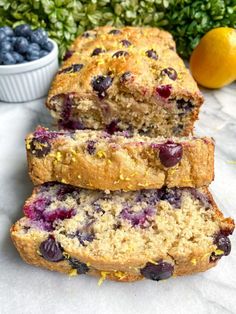 three slices of blueberry lemon bread are stacked on top of each other next to some fresh fruit