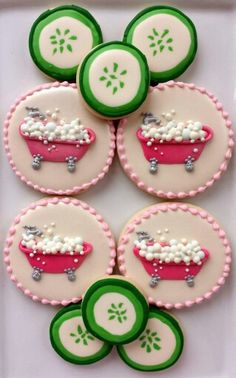 decorated cookies with green and pink icing are arranged on a white platter in the shape of a bathtub