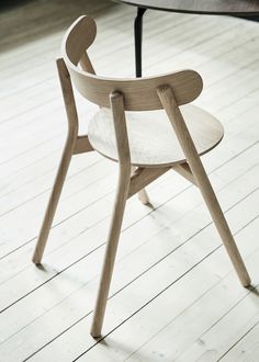 a wooden chair sitting on top of a hard wood floor next to a round table