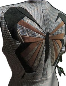 the back of a dress made out of plaid fabric with a large bow on it