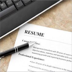 a resume is sitting on top of a desk next to a computer keyboard and pen