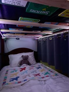 a teddy bear sitting on top of a bed in a room with lots of lights