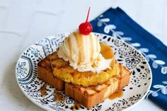 a piece of bread topped with ice cream and a cherry sitting on top of it