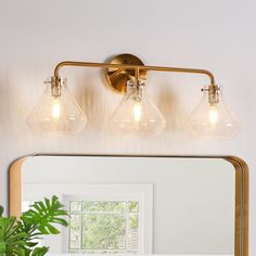 a bathroom light with three lights on the wall and a mirror in front of it