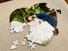 two people are kissing on a piece of jigsaw puzzle