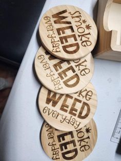 three wooden coasters with words on them sitting on a table next to a ruler