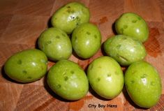 some green apples are sitting on a wooden table