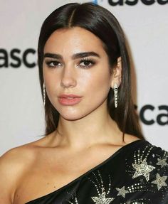 a close up of a person with long hair and wearing large hoop earrings on her head