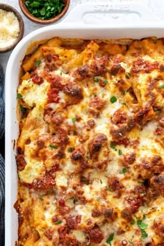 a casserole dish with meat and cheese in it next to some parsley