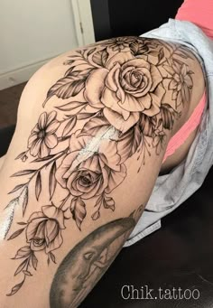 a woman's thigh with roses and leaves on her leg, in black and white