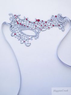 We offer original handcrafted embellishment designs for your mask. We can customize any mask to create a wearable work of art unique to you!Silver Masquerade Mask women Lace Red rhinestones Mardi Gras Mask These subtle yet seductive masks are each intricately embroidered to be a gorgeous addition to any costume or party dress that will transform you into a mystifying beauty of the night!  This pattern compliments all face shapes and is very comfortable to wear. Its also ideal to wear with eye gl Elegant Red Masks For Carnival, Elegant Silver Masks As Gift, Red Eye Mask As Gift, Red Eye Mask For Gift, Red Eye Mask As A Gift, Silver Rhinestone Eye Masquerade Mask, Silver Rhinestone Eye Mask For Masquerade, Carnival Rhinestone Masquerade Mask, White Eye Mask Masquerade Mask As Gift